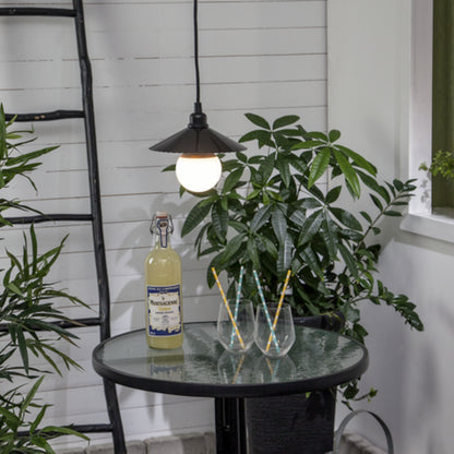 Lampeholder E27 med ledning udendørs monteret over rundt glasbord med lemonade og grønne planter, hvide vægge bagved.