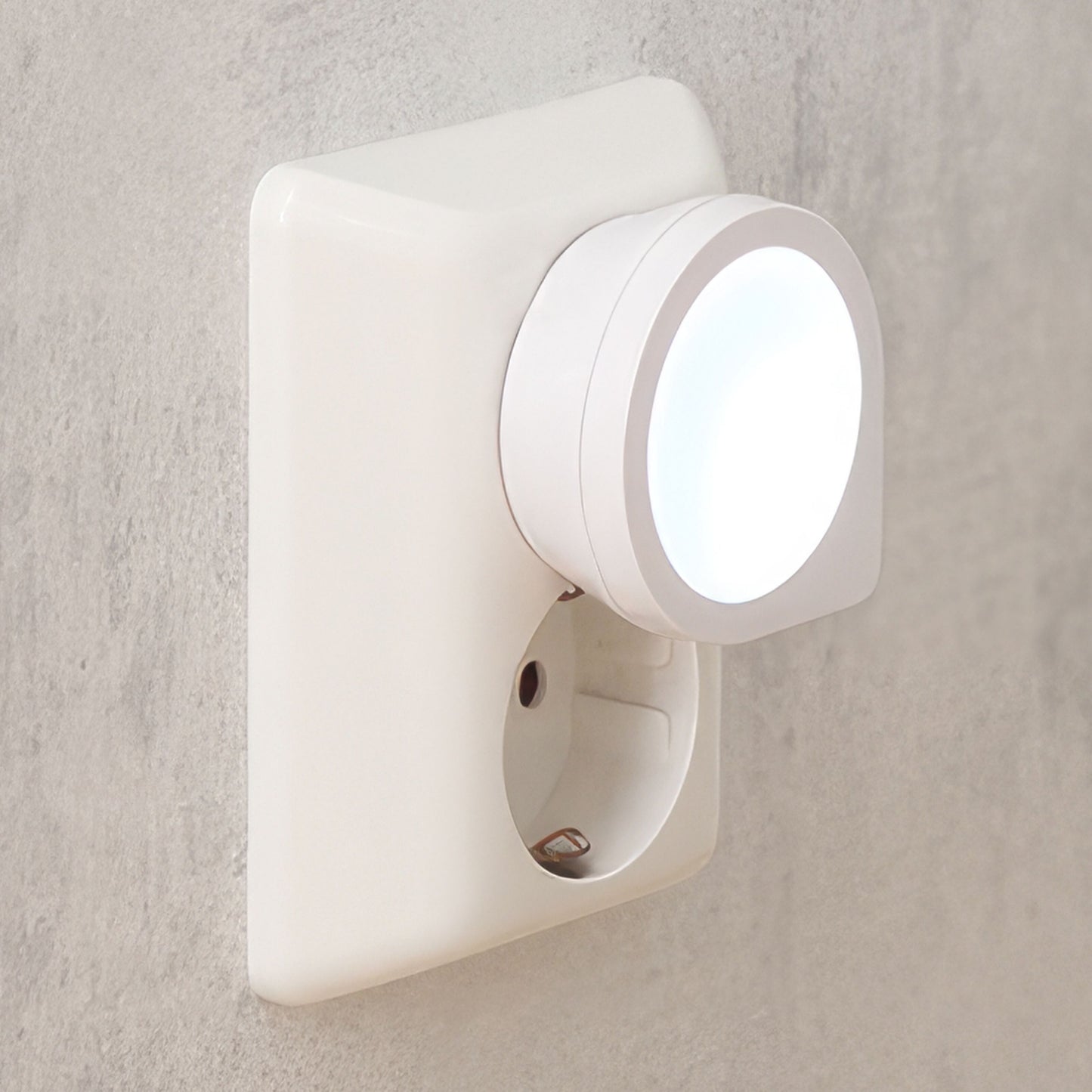 Luxorparts LED natlampe Mini til stikkontakt udsender cirkulær glød mod lys væg.