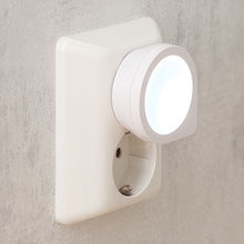 Luxorparts LED natlampe Mini til stikkontakt udsender cirkulær glød mod lys væg.
