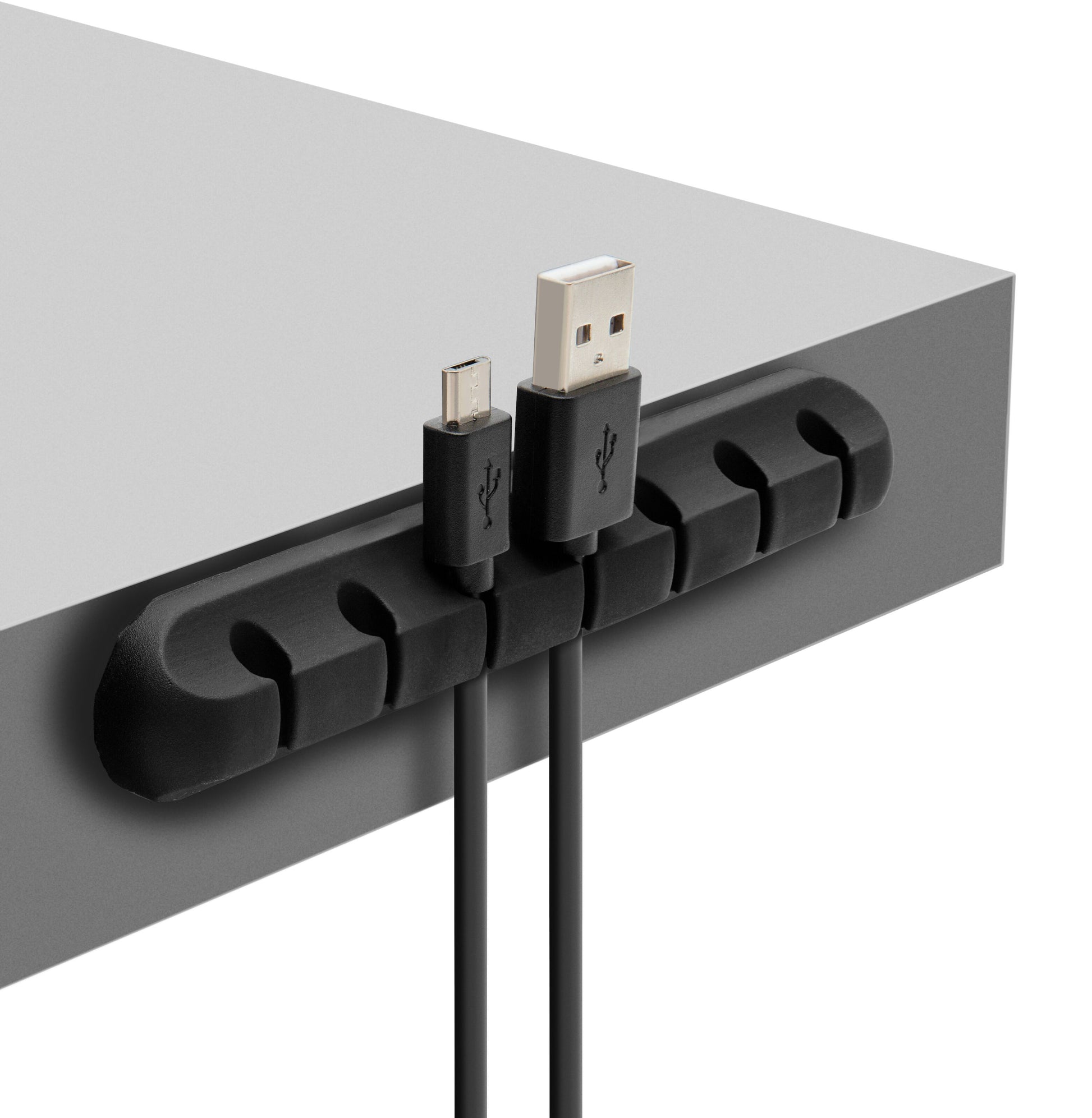 Luxorparts selvklæbende kabelholder sort monteret på grå bordplade holder USB- og mikro-USB-kabel adskilt.