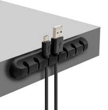 Luxorparts selvklæbende kabelholder sort monteret på grå bordplade holder USB- og mikro-USB-kabel adskilt.