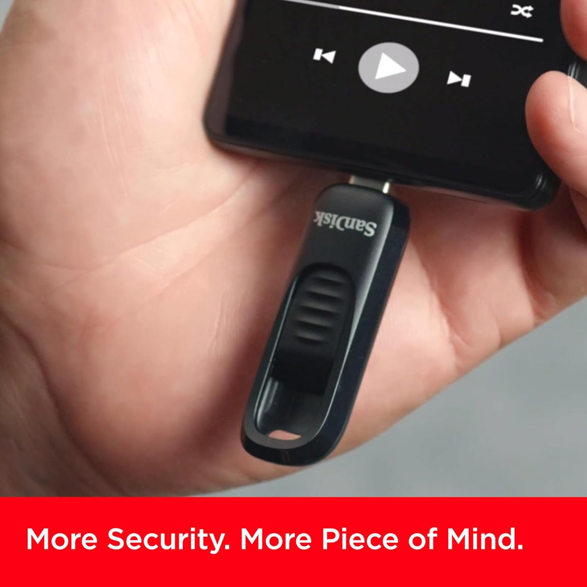 Sandisk Ultra Slide USB-C USB-nøgle 128 GB tilsluttes smartphone, skærm viser mediekontroller, tekst: Mere sikkerhed.
