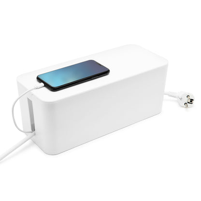 Kabelskjuler Maxi hvid organiserer ledninger med hvid strømkabel og stik synligt, smartphone oplades ovenpå.