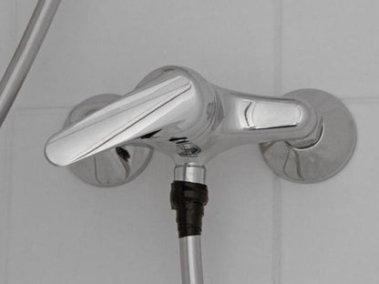 Krom brusearmatur på flisevæg med Vulkaniseret tape 10 m om tilslutning under for vandtæt forsegling.