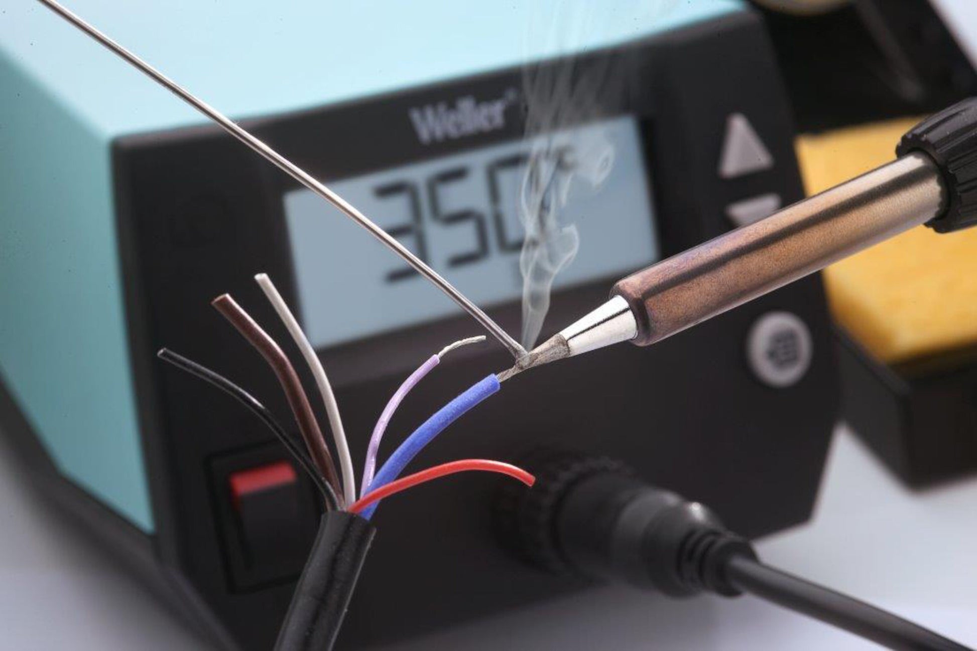 Weller WE 1010 Loddestation 70 W med display viser 350°C, loddekolbe varmer blottede ledninger, røg synlig.