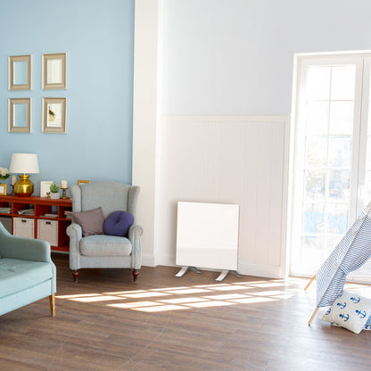 Cleverio Smart Radiator 1000 W hvid, elradiator under stort vindue i stue med blå væg og blå-hvid stribet pude.