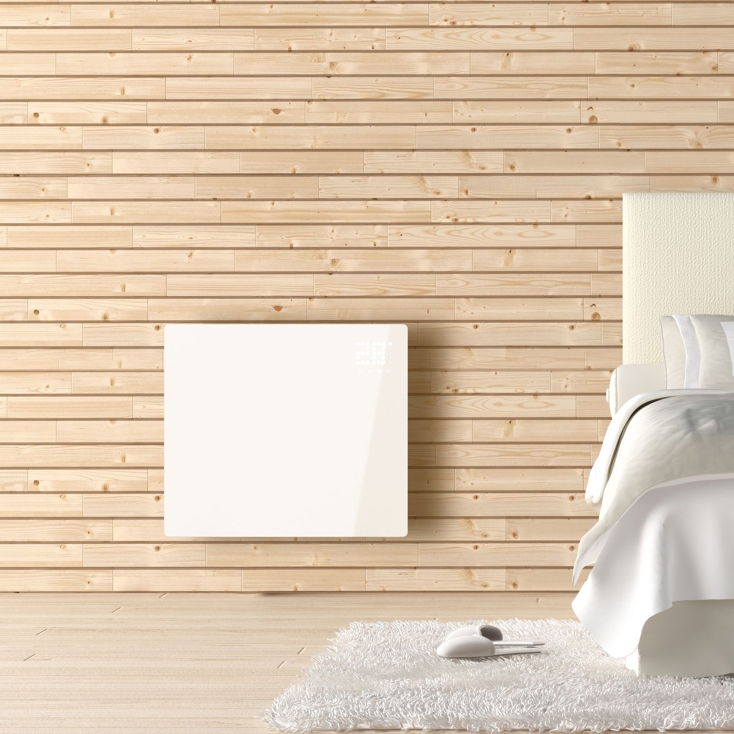 Cleverio Smart Radiator 1000 W el-radiator i hvid monteret på trævæg ved seng, hvidt tæppe og hjemmesko på gulvet.