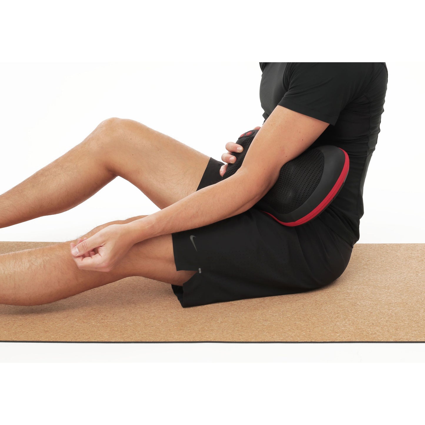 Flowpillow Varmemassagepude med infrarød varme på mave, sort sportstøj, hånd på knæ, anden holder puden.