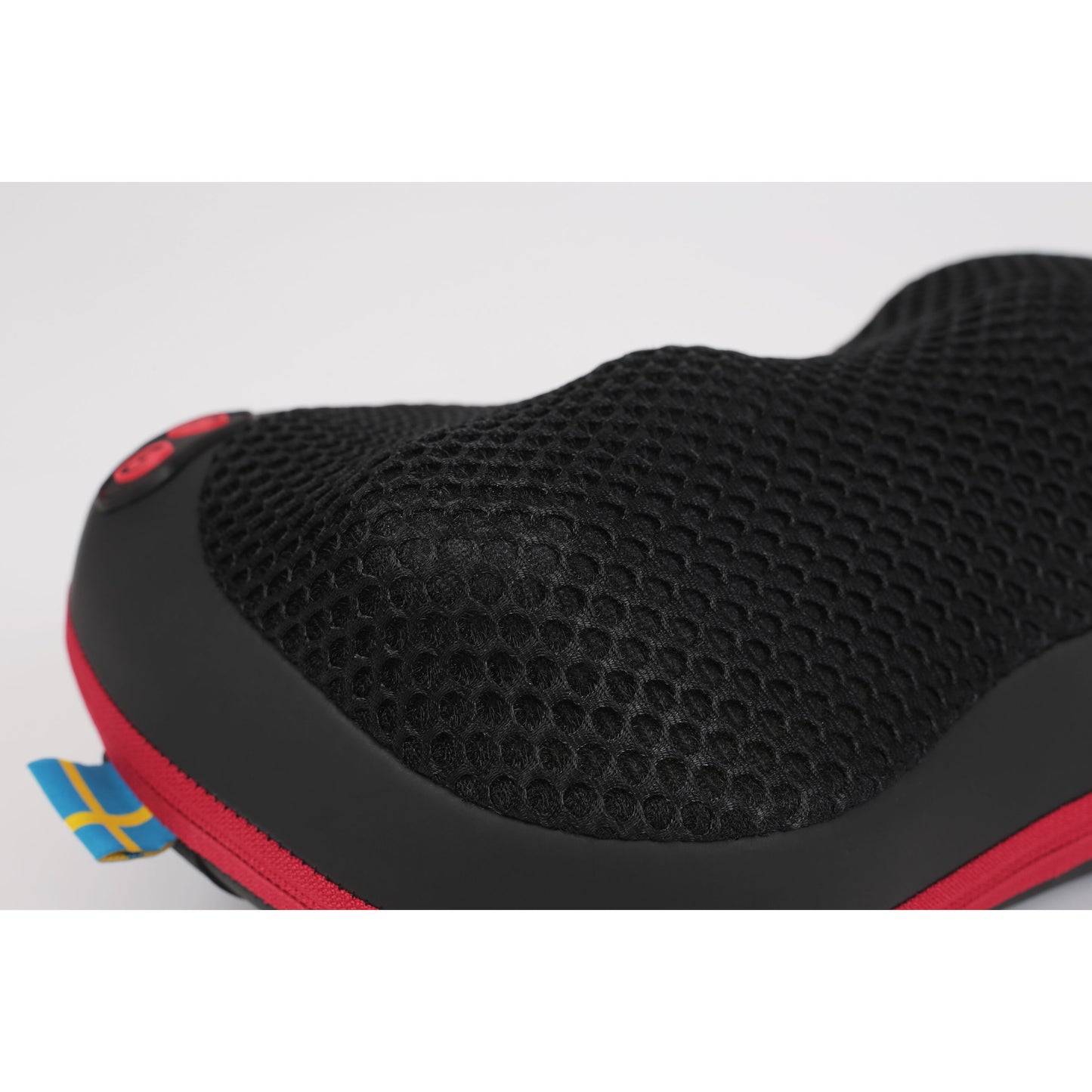 Flowpillow Varmemassagepude, sort mesh med rød kant og lille svensk flagmærke.