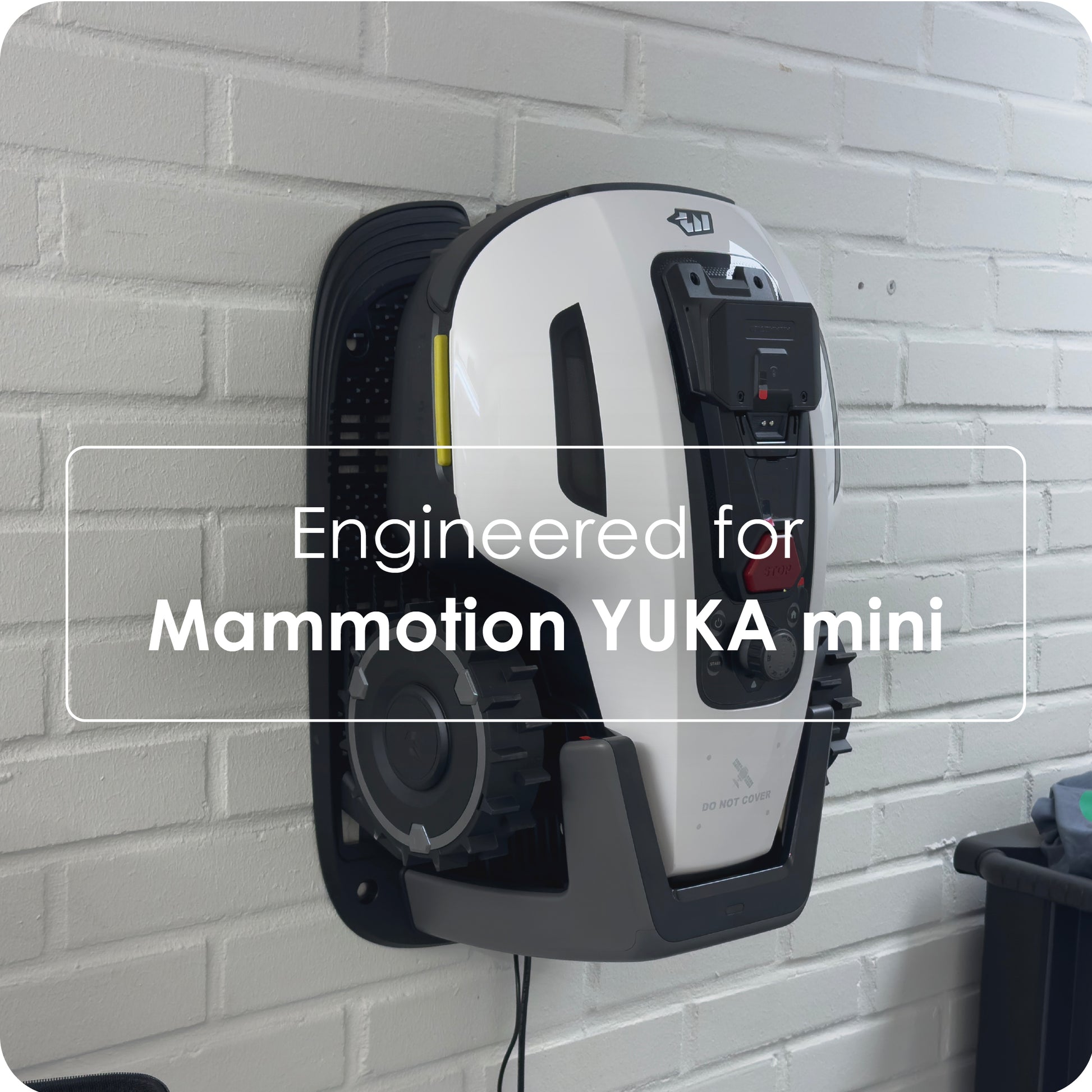 Mammotion Yuka Mini robot, hvid/sort, på dock med teksten "Vægholder til Mammotion Yuka Mini, robotplæneklipper opbevaring.