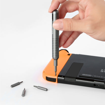 Præcisions skruetrækker fra Skrue sæt 48 dele løsner skrue bagpå orange-sort Nintendo Switch, tre bits ved siden af.