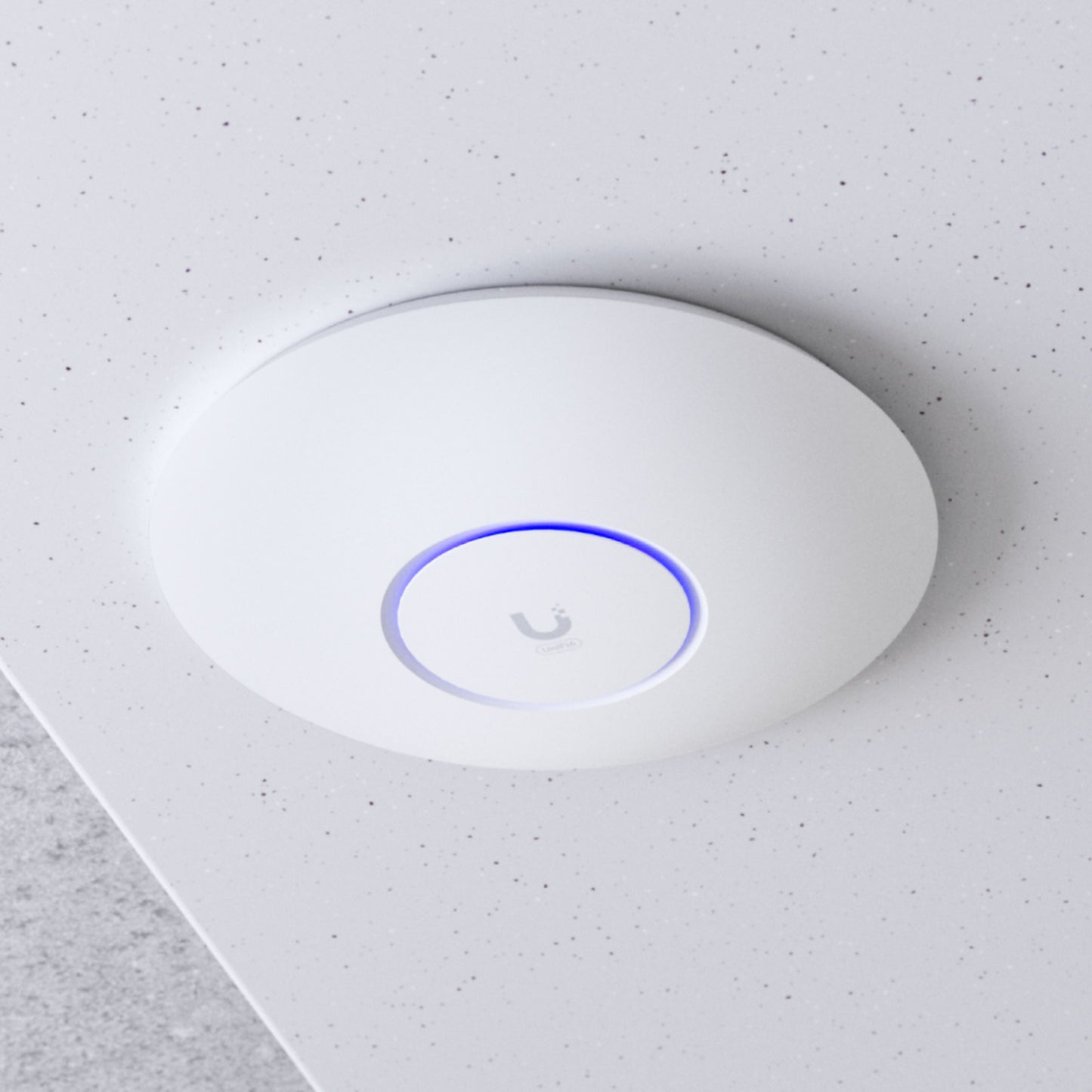Ubiquiti UniFi U6+ WiFi 6 access point, rund, hvid, blå LED-ring, Ubiquiti-logo, monteret i hvidt loft, PoE 802.11af.