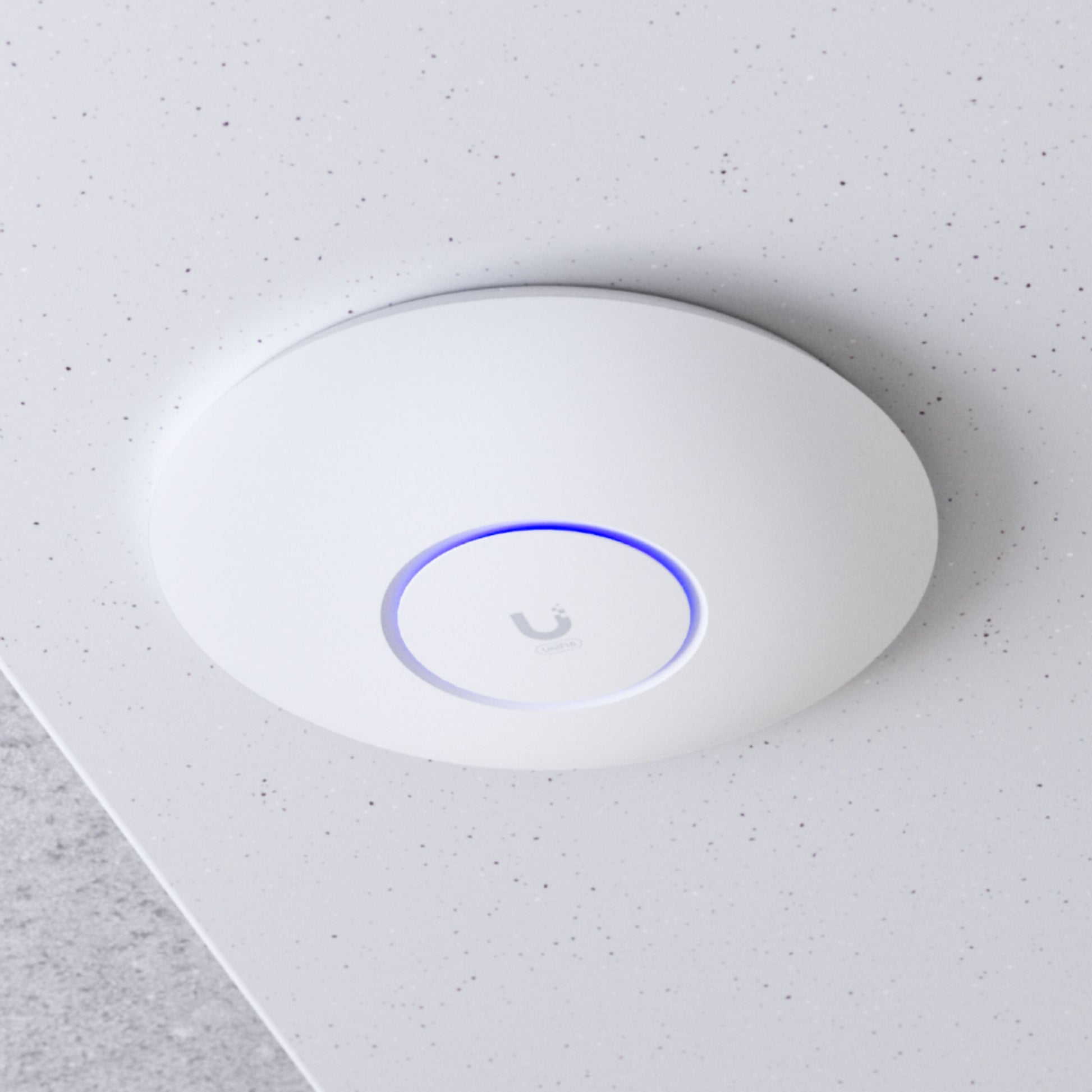 Ubiquiti UniFi U6+ WiFi 6 access point, rund, hvid, blå LED-ring, Ubiquiti-logo, monteret i hvidt loft, PoE 802.11af.