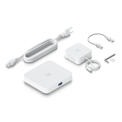 Ubiquiti UCG-Max Cloud Gateway Max Wi-Fi router kit med kvadratisk router, strømforsyning, Ethernetkabler og monteringsbeslag.