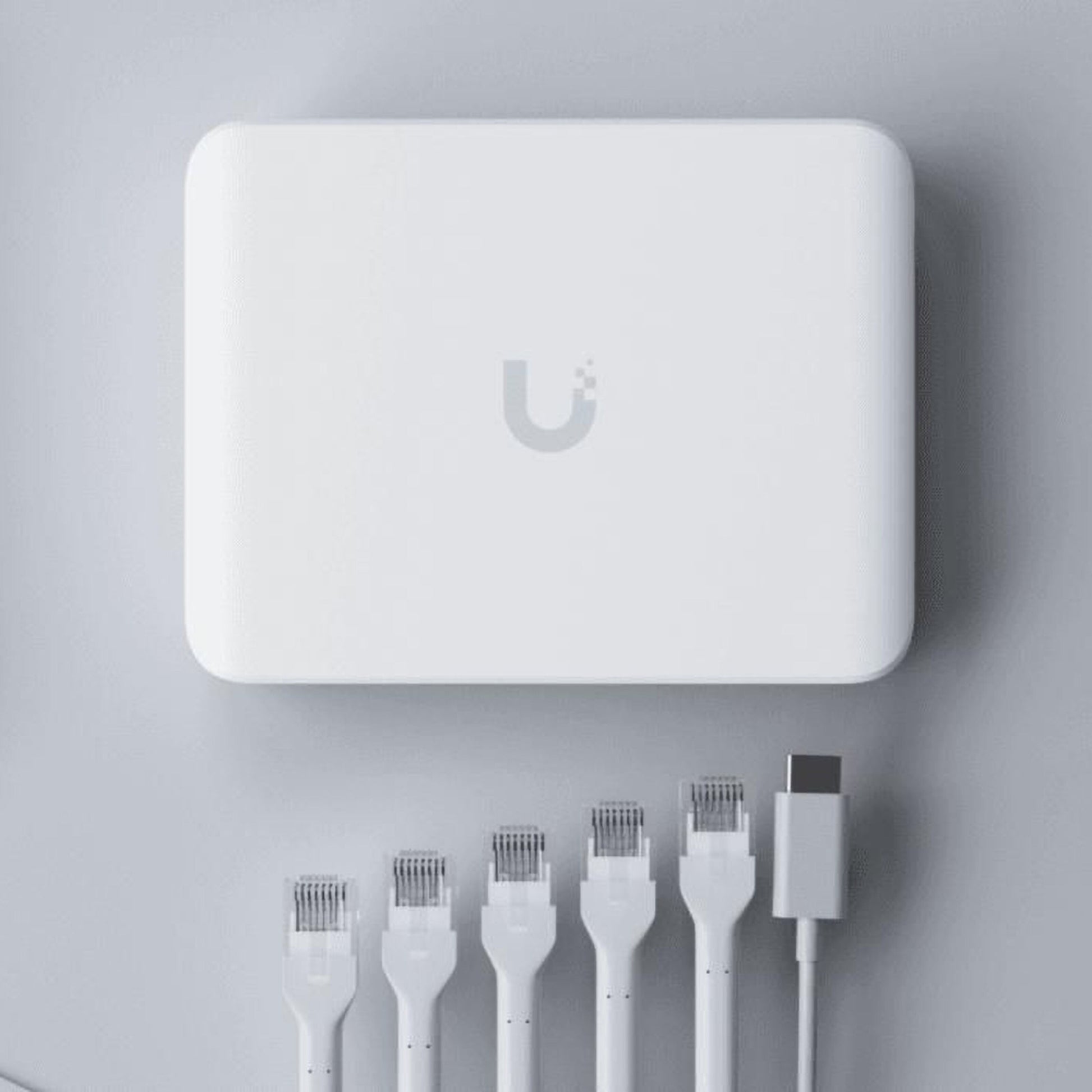 Ubiquiti Switch Flex Mini 2,5G 5P hvid, to PoE-porte, fem Ethernet-kabler og et USB-C-kabel synlige.