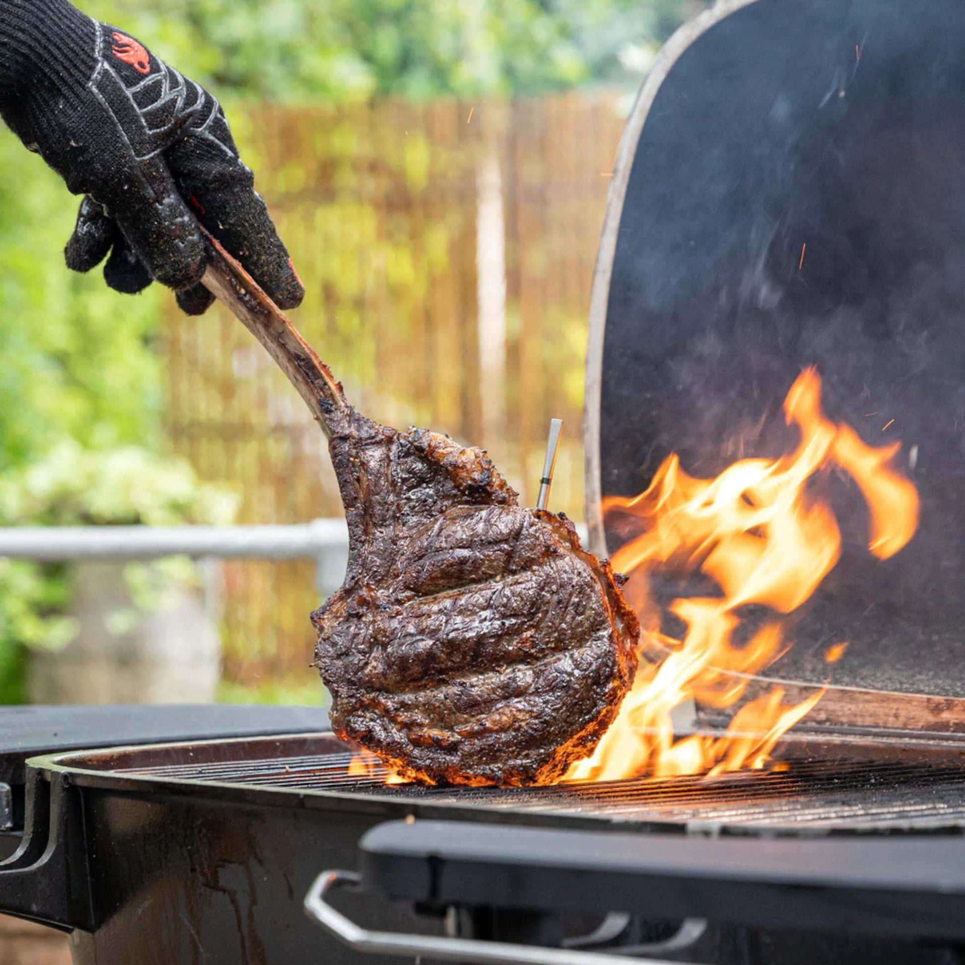 Meater 2 Plus trådløst grilltermometer måler kernetemperatur i bøf på grill, synkroniseret med mobil.