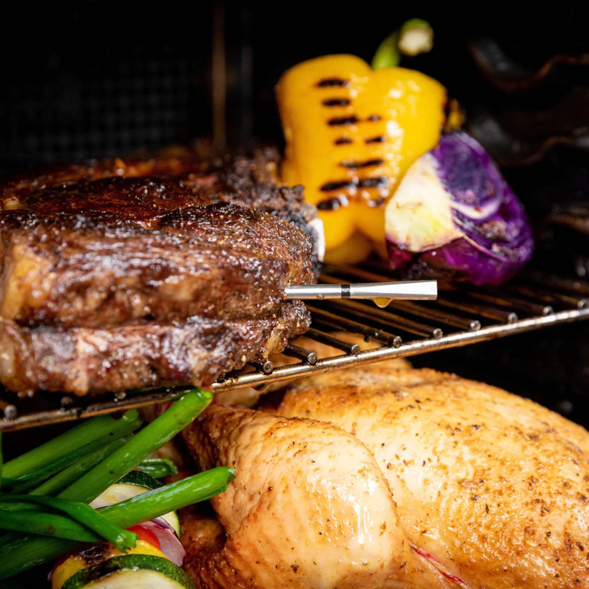 Meater 2 Plus trådløst grilltermometer ved stegt kylling, bøf og grøntsager, inkl. gul peber, lilla kål og grønne bønner.