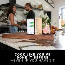 Meater Pro Duo trådløs stegetermometer (wifi) i træholder ved stegt kød, mobil viser Meater-app.