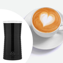 Rubicson mælkeskummer til varm og kold mælk ved siden af cappuccino med hjerteformet latte art på hvid underkop.