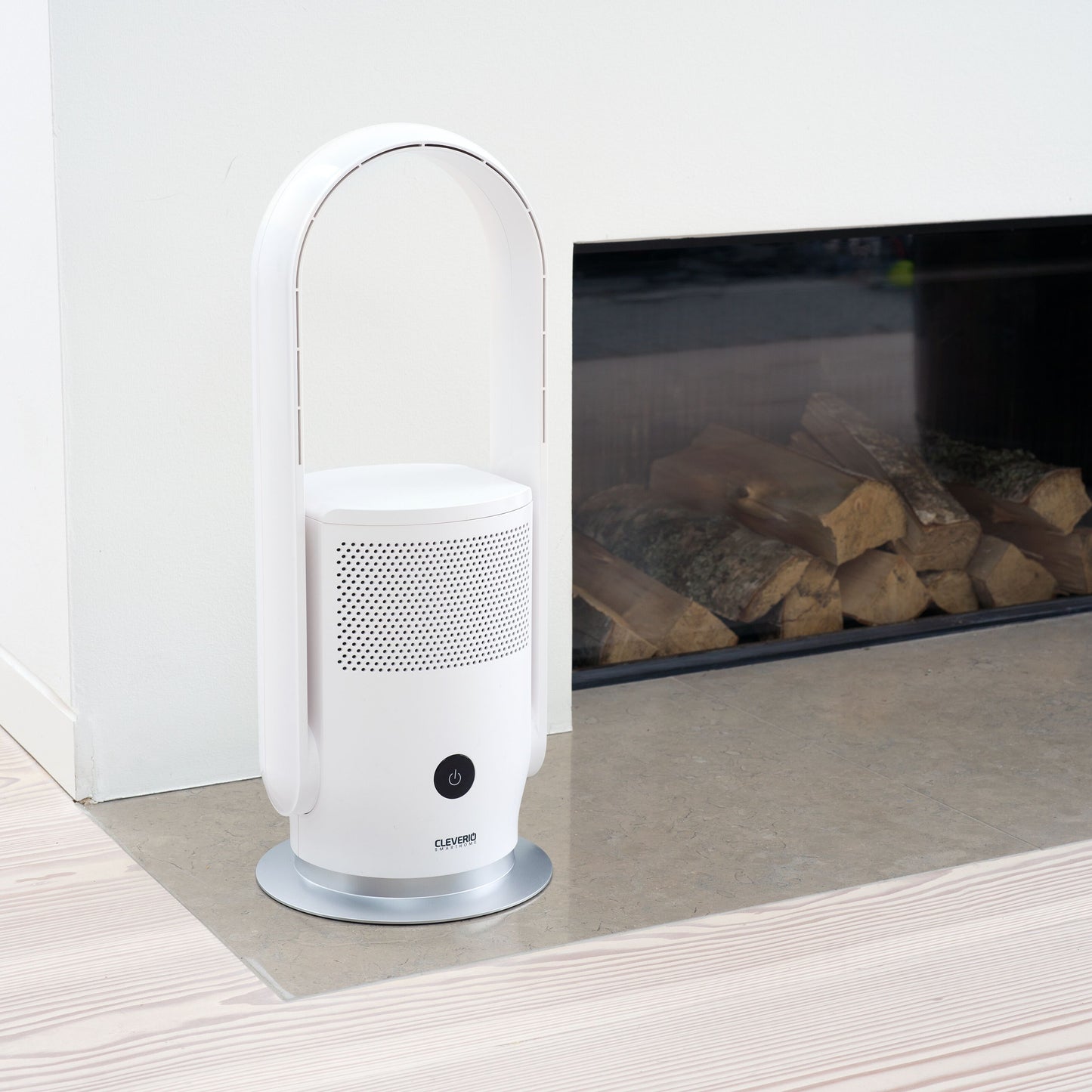Cleverio AF-F100 gulvventilator med luftfilter på grå stenpejs foran pejs med stablede brændeknuder.