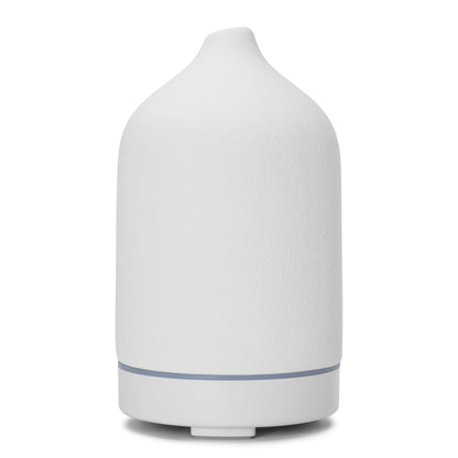 Aromadiffuser med ultralyd, hvid keramik med mat finish, afrundet krop, smal tud, diskret blå kant.