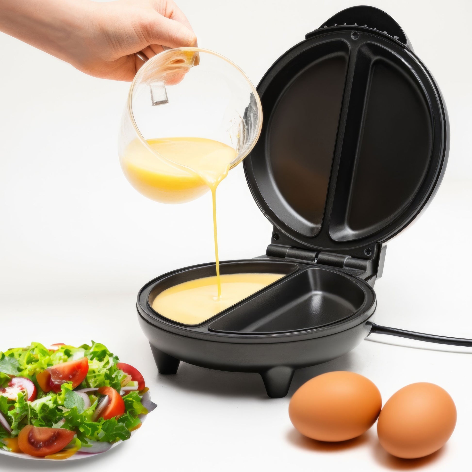 Rubicson Omeletjern med non-stick belægning, æg hældes i, til hele æg og salat med tomater ved siden af.