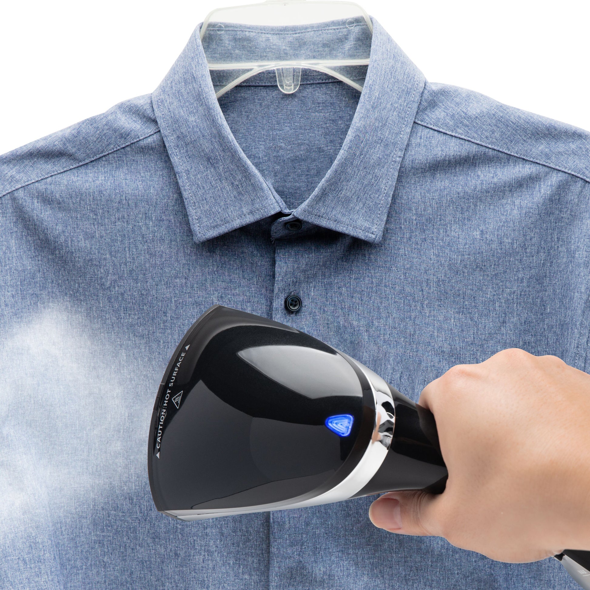 Rubicson tøjdamper fjerner folder fra blå button-up skjorte på bøjle med synlig damp mod stoffet.