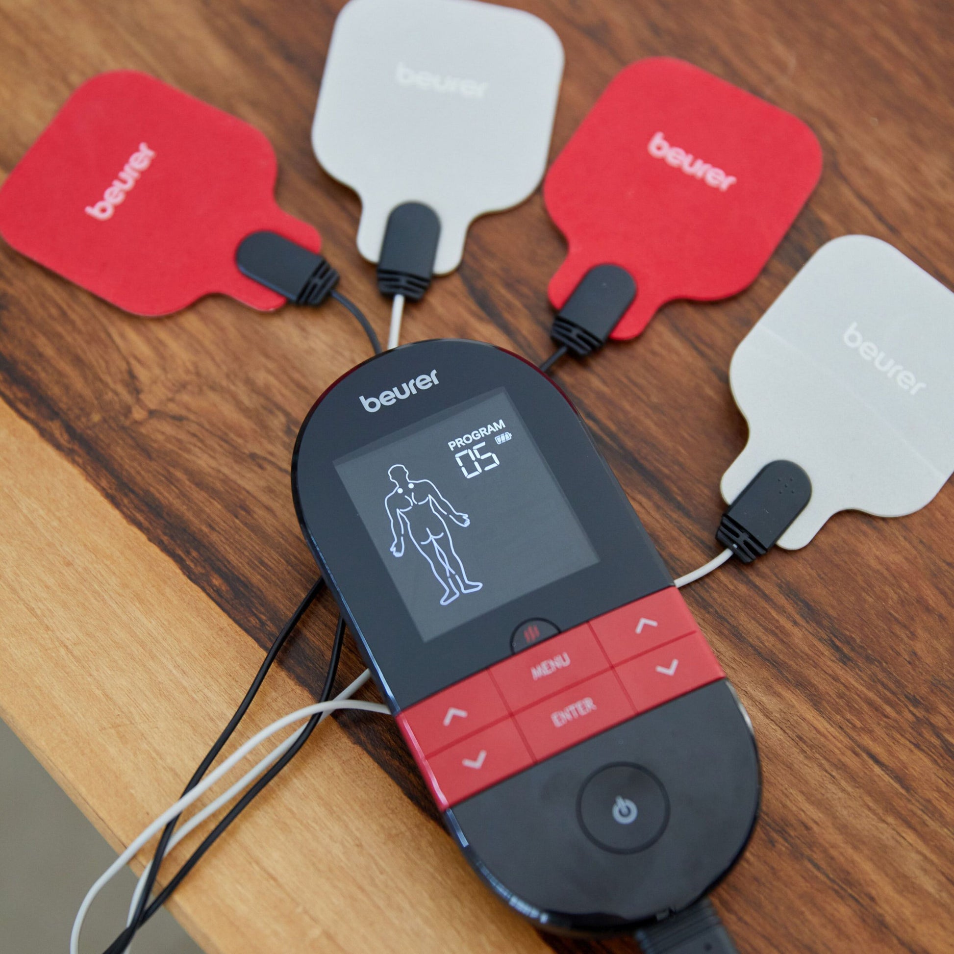 Beurer EM 59 TENS/EMS muskelstimulator med varme, fire elektrodepads, display med programinfo og menneskefigur.