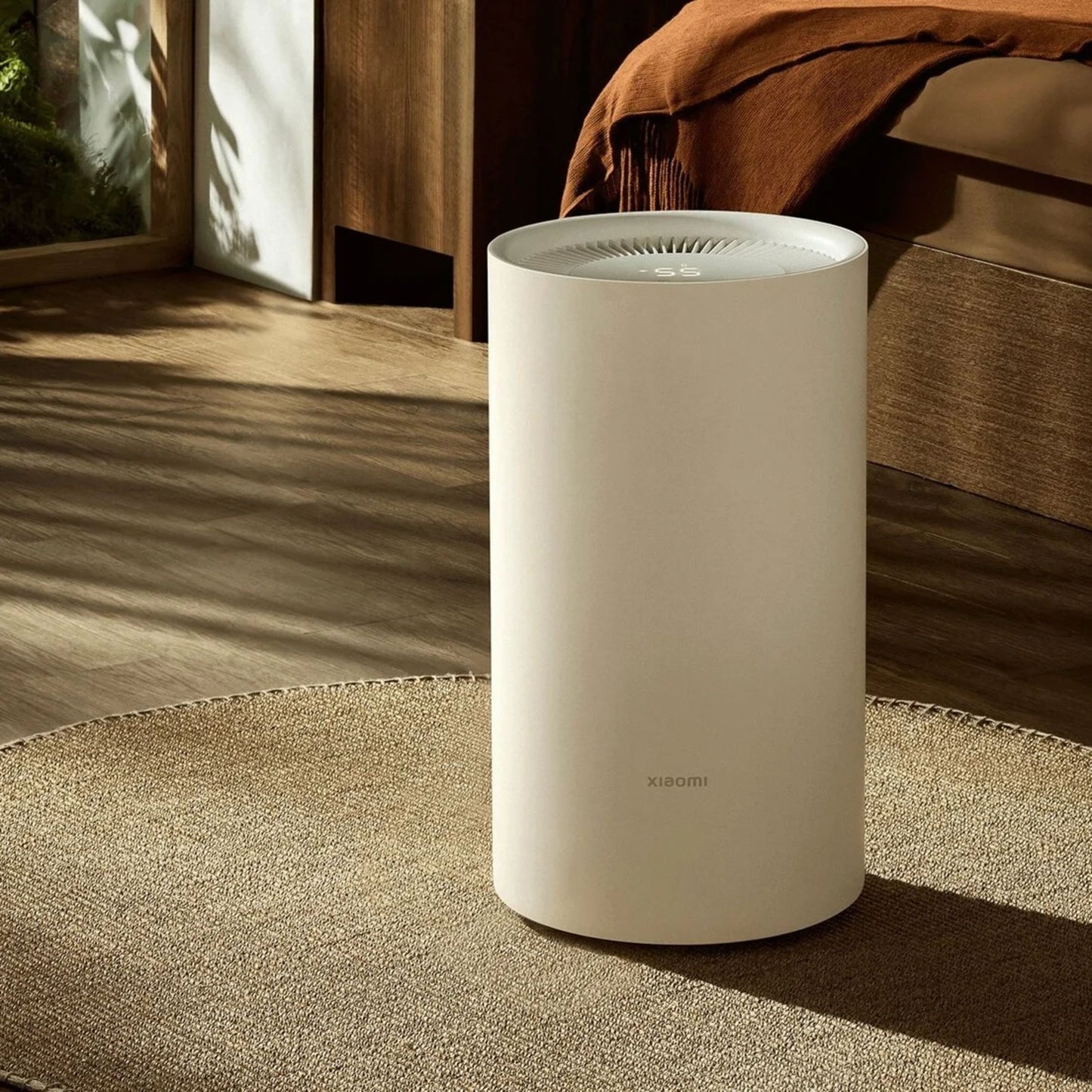 Xiaomi Smart Affugter Lite 13 l/døgn hvid cylinder med ventileret top på rund måtte i værelse med trægulv og orange plaid.