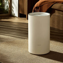 Xiaomi Smart Affugter Lite 13 l/døgn hvid cylinder med ventileret top på rund måtte i værelse med trægulv og orange plaid.