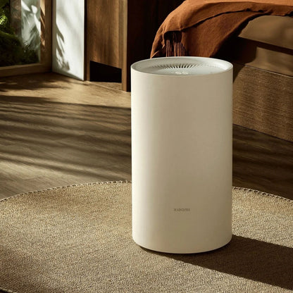 Xiaomi Smart Affugter Lite 13 l/døgn hvid cylinder med ventileret top på rund måtte i værelse med trægulv og orange plaid.