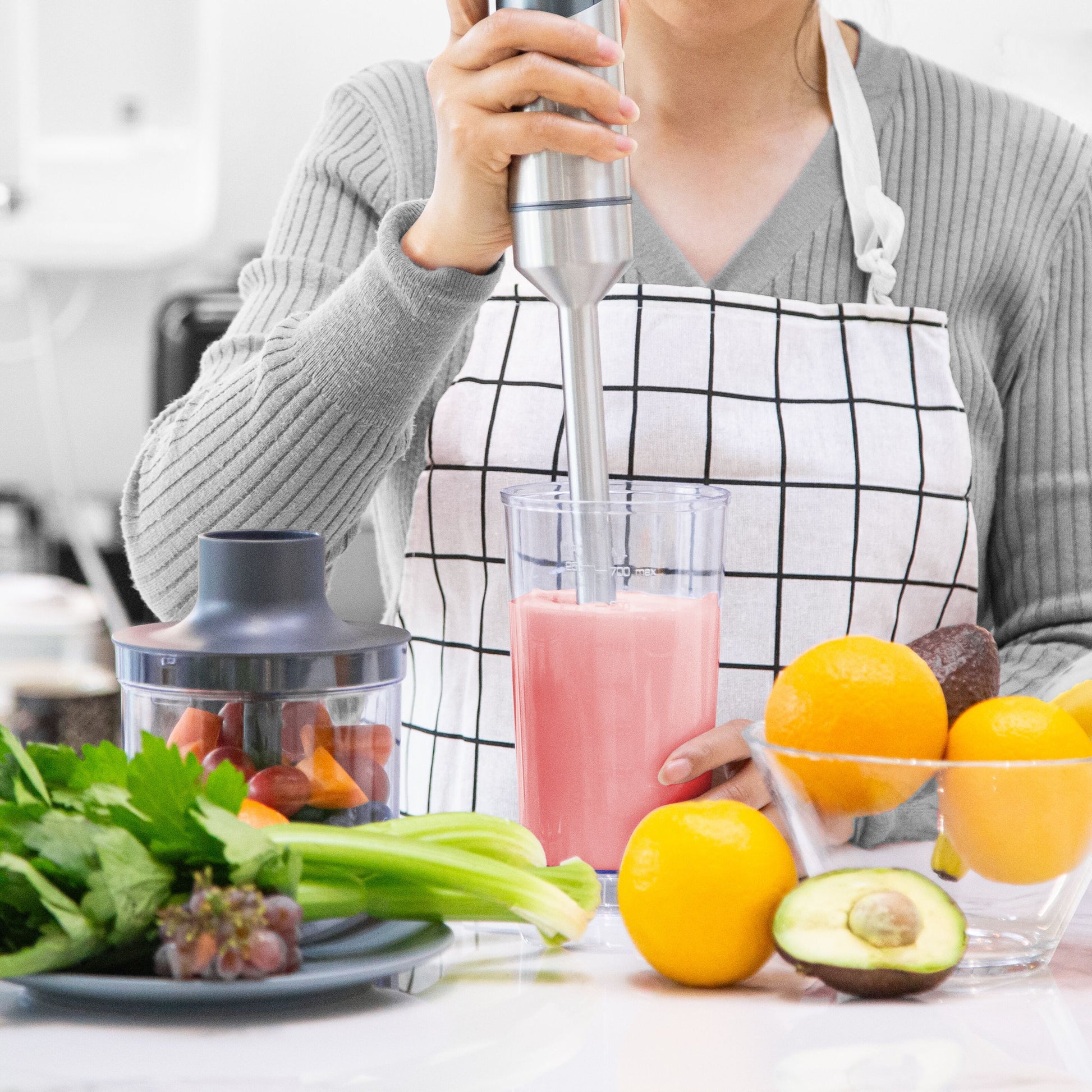 Trådløs stavblender med USB-C opladning i brug til pink smoothie, frugt og grønt synligt på køkkenbord.