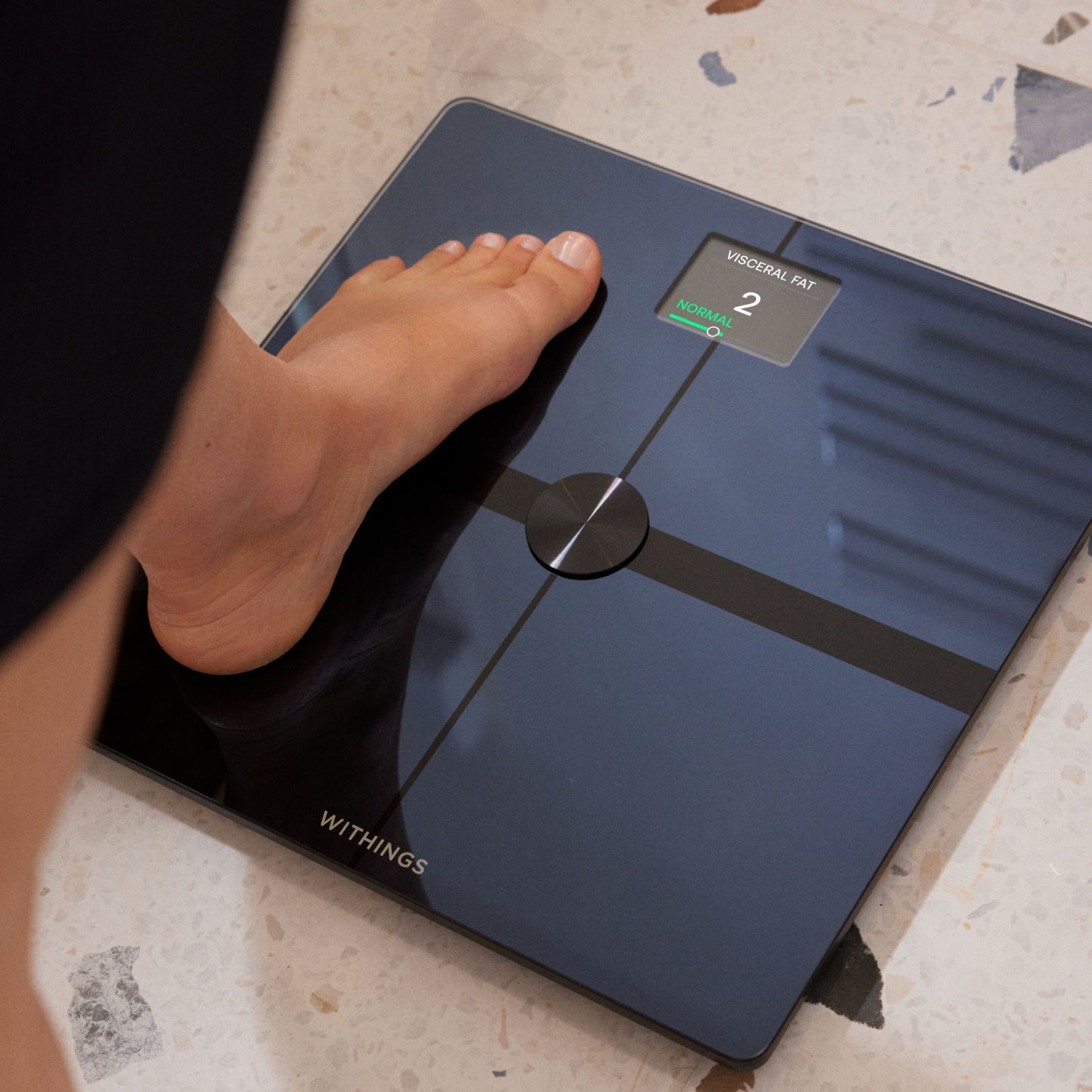 Withings Body Smart personvægt med wifi, sort, på terrazzo, display viser visceral fedtscore 2 markeret Normal i grøn.