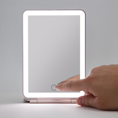 Makeup spejl med LED-belysning, rektangulært bordmodel, LED-lys langs kanterne, hånd ved tænd/sluk-knap.