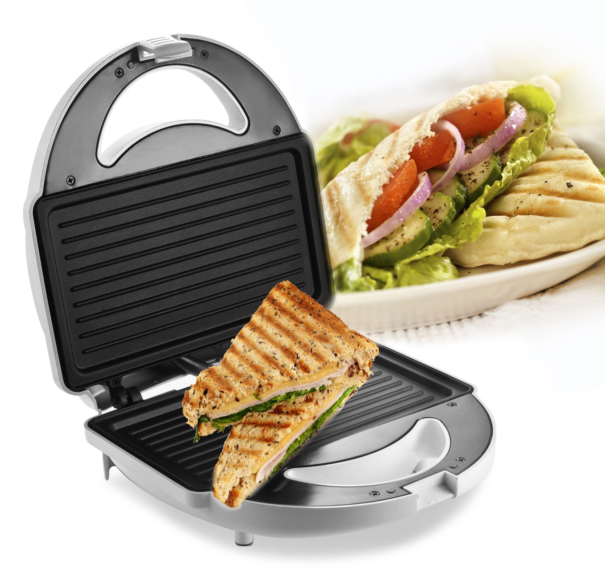 Rubicson Smørrebrødsgrill åben med grillet sandwich på non-stick plade, wrap med grønt på hvid tallerken i baggrunden.