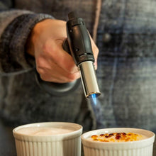 Rubicson Crème brûlée brænder med justerbar flamme brugt til at karamellisere sukker på to crème brûlée i ramekiner.