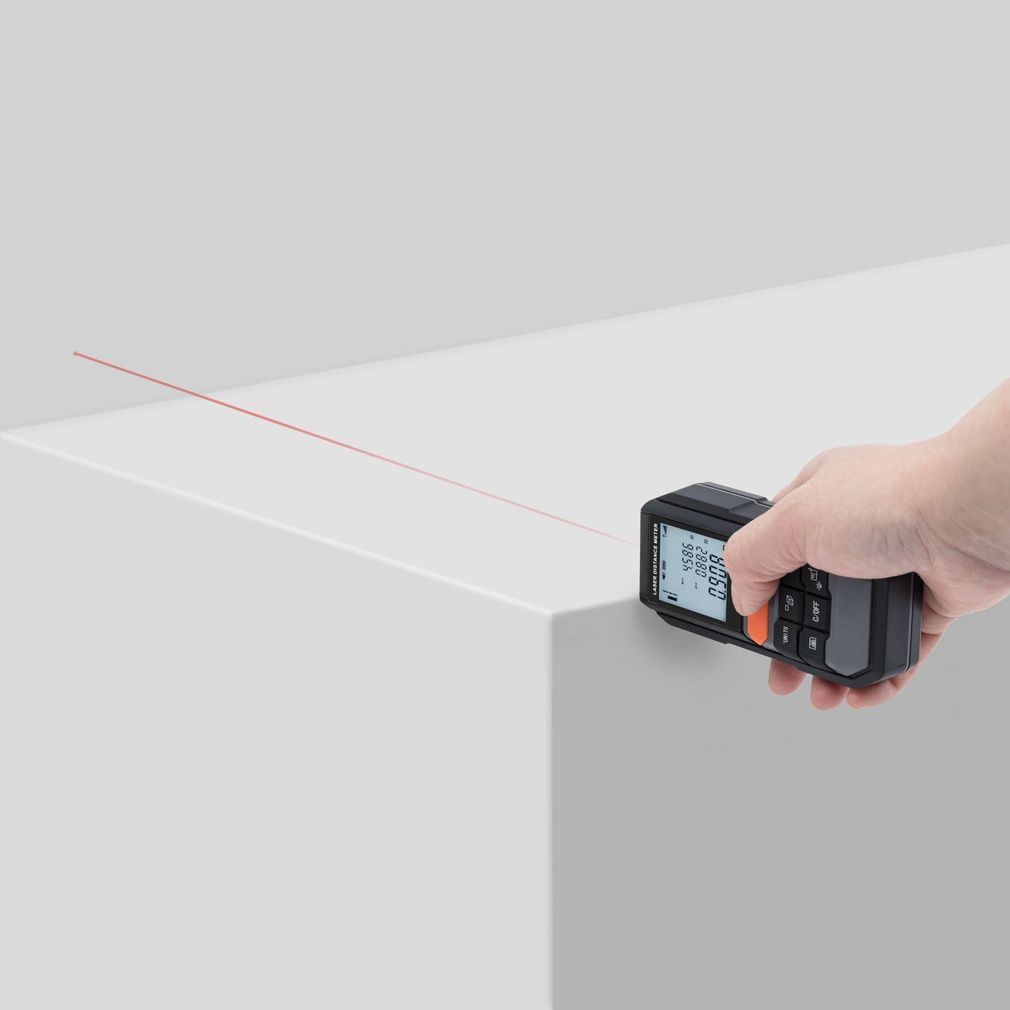 Luxorparts Afstandsmåler måleinstrument, vises i hånd med rød laserlinje til længdemåling af hvid overflade.