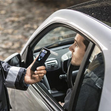 Dräger Alcotest 6000 Alkometer bruges af politibetjent til professionel alkoholtest gennem bilrude.