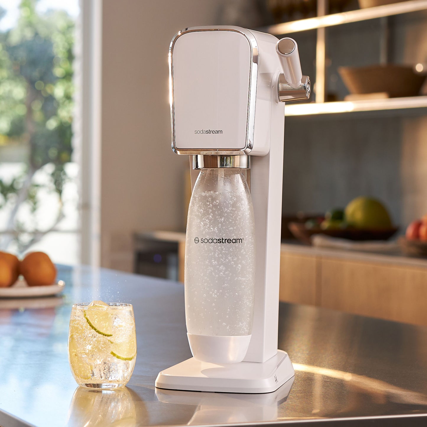 Sodastream sodavandsmaskine på bord ved siden af glas danskvand med lime.