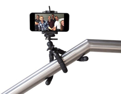 Linocell stativ til kamera og mobil med fleksible ben fastgjort om metalgelænder holder smartphone med gruppe-selfie.