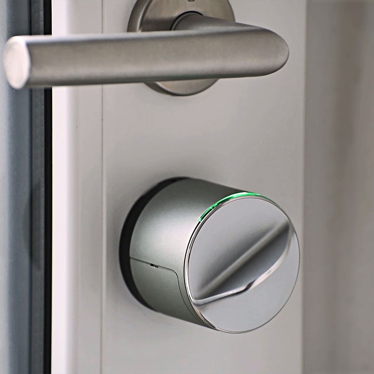Danalock V3 Scandi elektronisk dørlås, metallic finish, rund med grøn indikator, Bluetooth og Z-wave, under sølvhåndtag.