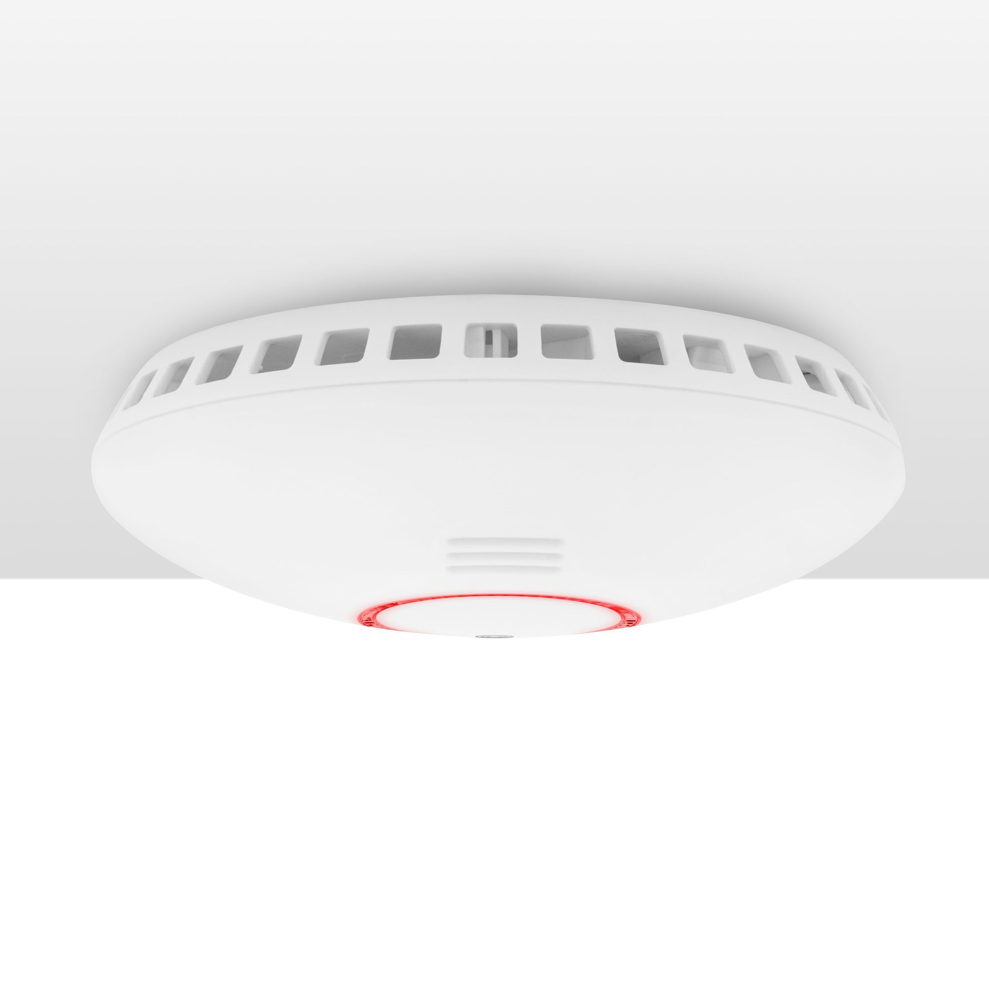 Cleverio Smart røg- og varmedetektor, hvid, monteret i loft med rød indikator, WiFi alarmsystem integration.