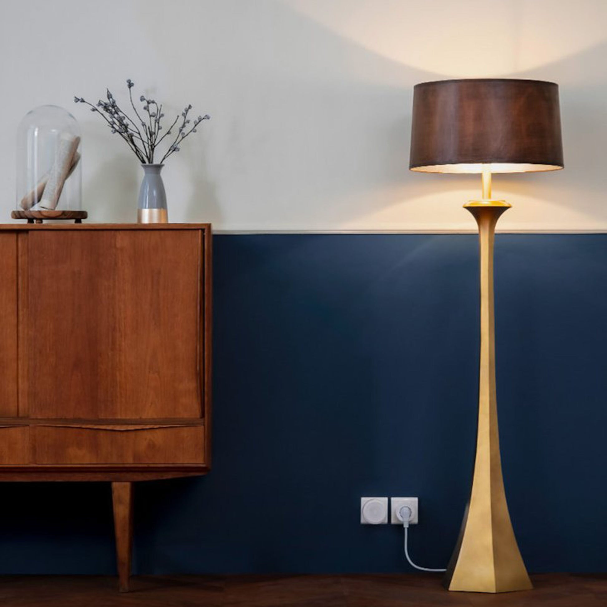 Aqara Smart stikprop i stikkontakt, hvid, synlig på halv-blå/halv-hvid væg ved træskab og gulvlampe.