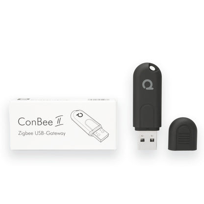 Sort Conbee II Zigbee USB-controller uden hætte ved siden af æske markeret med Conbee II Zigbee USB-Gateway.