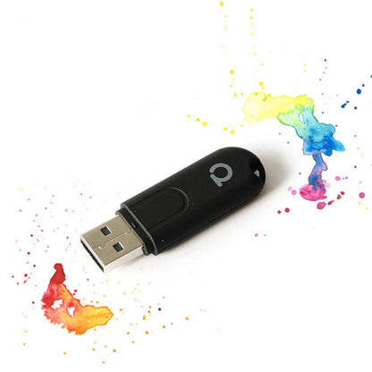 Conbee II Zigbee-controller USB sort med sølv stik, omgivet af farverige malerstænk.