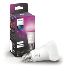 Philips Hue Color Ambiance E27 LED-pære 1100 lm i æske med lilla-lyserød gradient, pære lyser pink, label synlig.