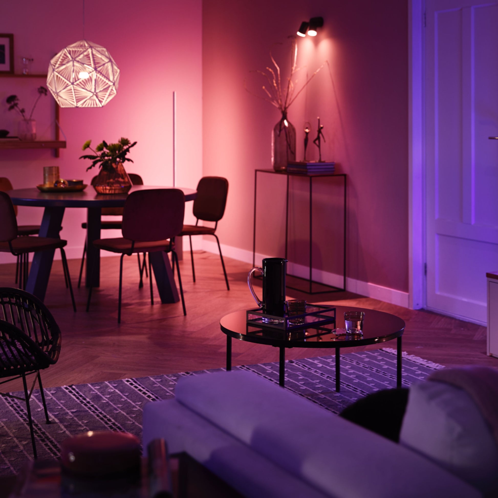 Philips Hue Color Ambiance Startpakke Smarte LED-pærer 2-pakke lyser stue med rundt spisebord, stole og pendellampe.