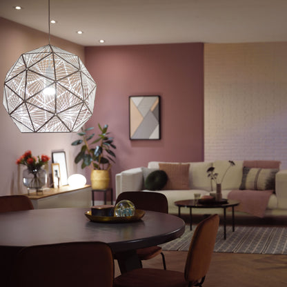Hue Hvid Smart LED-pære E27 1100 lm i geometrisk pendel over rundt bord med brune stole, hvid sofa, abstrakt vægkunst.