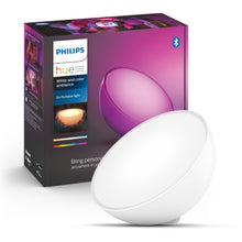 Philips Hue Go bærbar bordlampe med lilla lys foran emballage, Bluetooth og farveskift nævnt på æsken.