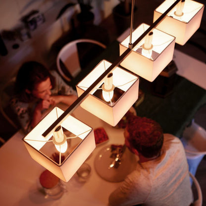 Philips Hue Hvid Smart LED-pære E14 470 lm 2-pak, dæmpbart varmt hvidt lys, fire pendler over spisebord.